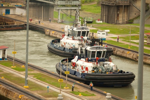 big ol' beefy tugs help steer the big ships toward the locks